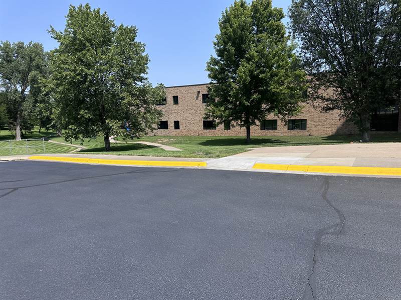 Bright yellow painted curb along a parking lot drive aisle